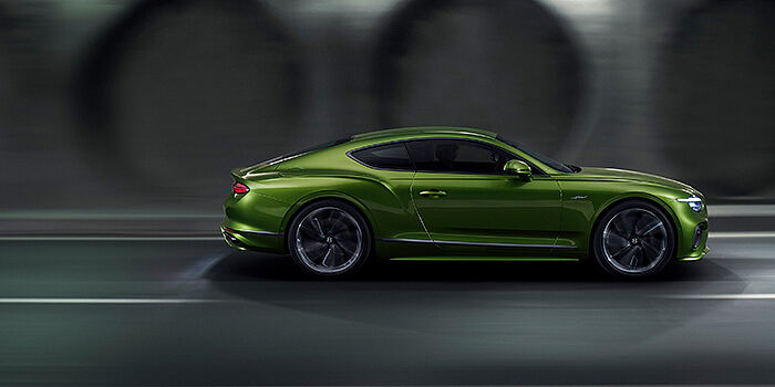  Bentley St Peter Bentley Continental GT coupe in Tourmaline Green paint driving in profile on a dark road