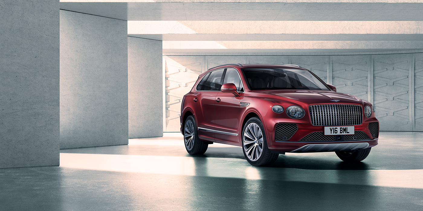 Bentley St Peter Bentley Bentayga Atelier Edition SUV in Rubino Red paint front three quarter against textured concrete wall