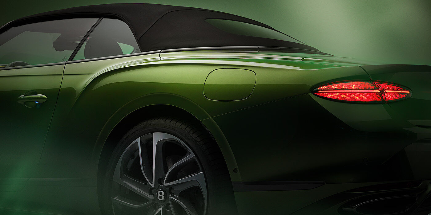 Bentley St Peter Bentley New Continental GTC Speed rear haunch and tail lamp in Tourmaline Green paint and dark tint brightware with black hood up and illuminated head lamps