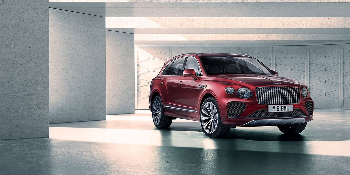 Bentley St Peter Bentley Bentayga Atelier Edition SUV in Rubino Red paint front three quarter against textured concrete wall