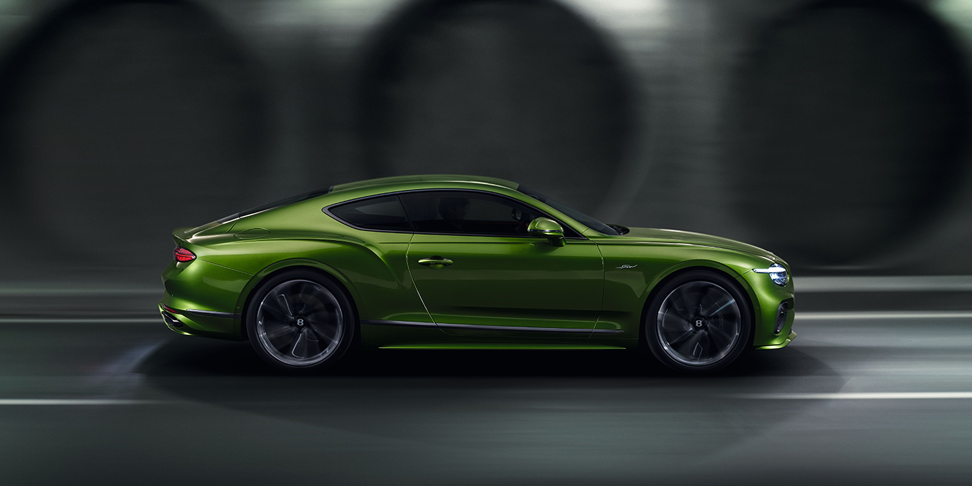 Bentley St Peter Bentley Continental GT coupe in Tourmaline Green paint driving in profile on a dark road