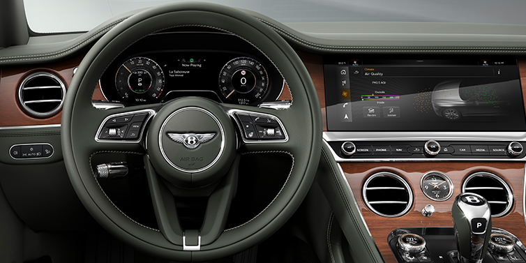 Bentley St Peter New Bentley Continental GT coupe steering wheel and front cabin view in Cumbrian Green hide and Crown Cut walnut veneer